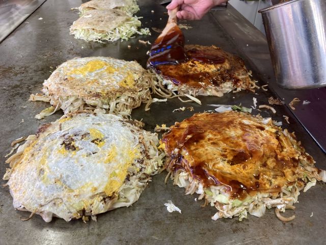 A photo of cooking okonimiyaki